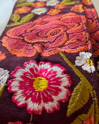 Close-up of embroidered fabric with floral patterns on a dark purple background