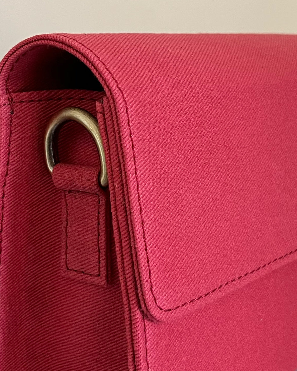 Close-up of a red bag with a strap and buckle detail.