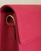Close-up of a red bag with a strap and buckle detail.