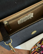 Inside of a black sling crossbody bag with inside zipper and clasp for keys , featuring a visible brand label -Neonia.