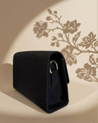 Black rectangular pouch with floral shadow on a beige background