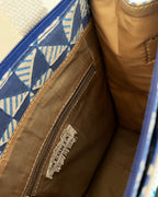 Close-up of a bag with a blue geometric pattern and visible brand logo.